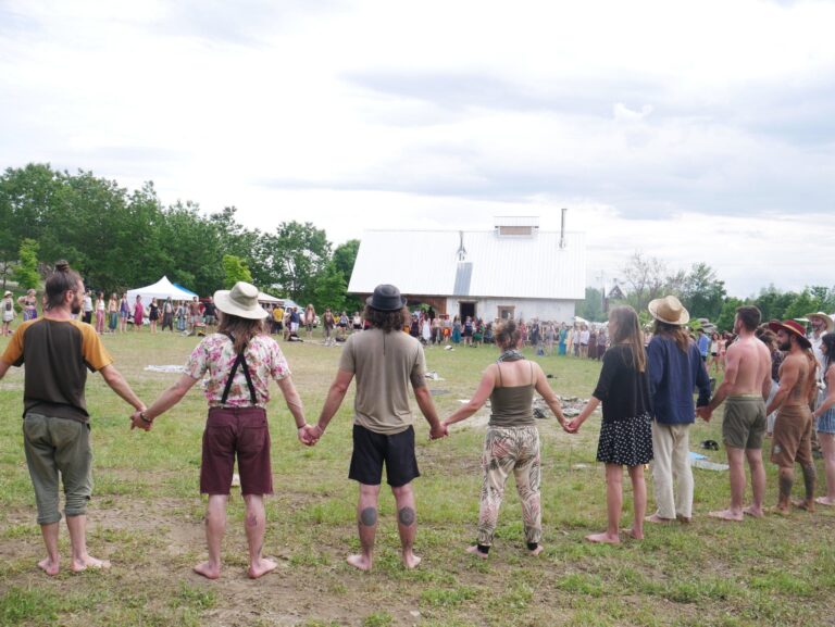 Participants se tenant la main en cercle au rassemblement Love 'N' Light à Tinwick (Warwick)